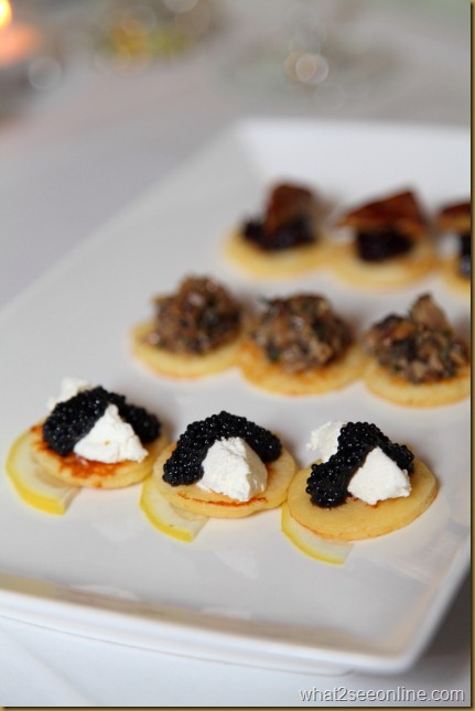 Blinis topped with sour cream, lemon and caviar 