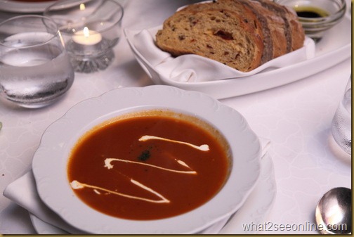 The classic tomato soup is served topped with parsley and a swirl of cream_resize